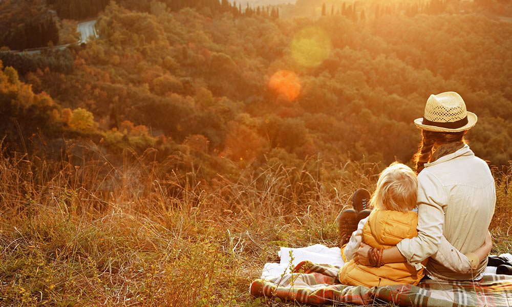 Blog - How Much Life Insurance Do I Need - Mother and Daughter Looking Off Into The Distance While The Sun Sets Over The Mountains