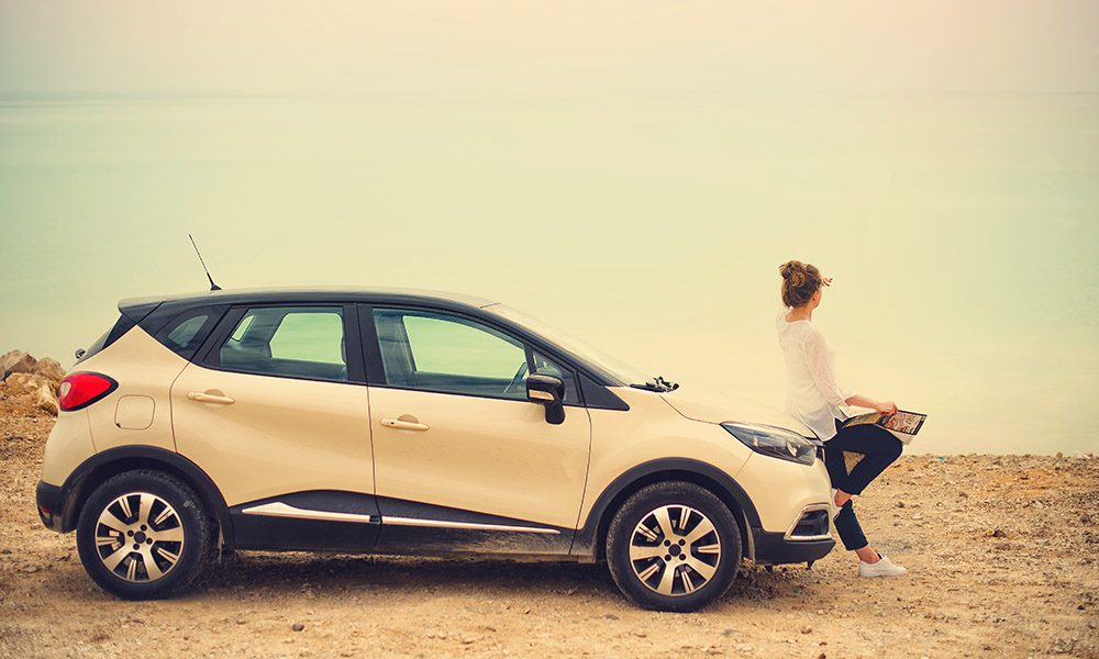 Blog - 8 Insurance Myths - Girl Sitting On Her Car Looking At The Horizon